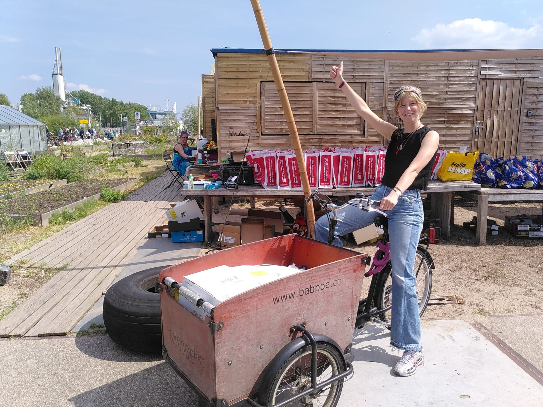 Vrijwilliger met de rode bakfiets bij de uitgiftetafels