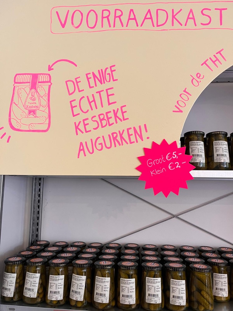 Een klant met een boodschappenmand kijkt naar de schappen met drinken en houdbare producten