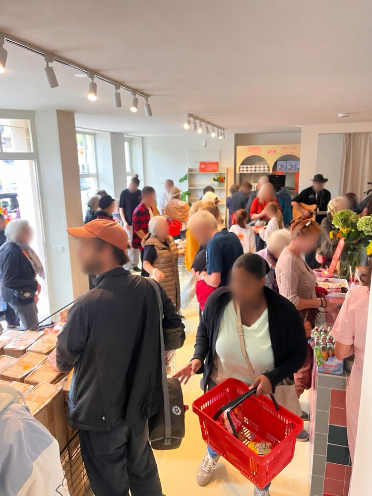 Een volle winkel met bezoekers en livemuziek op de opening