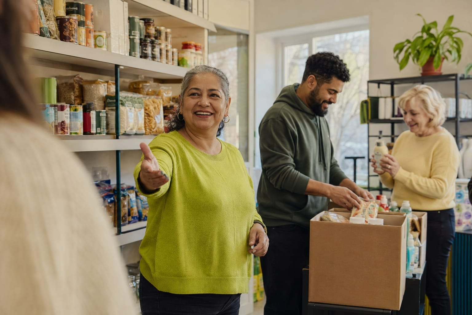 Klanten en vrijwilligers tussen de schappen van een sociale buurtwinkel